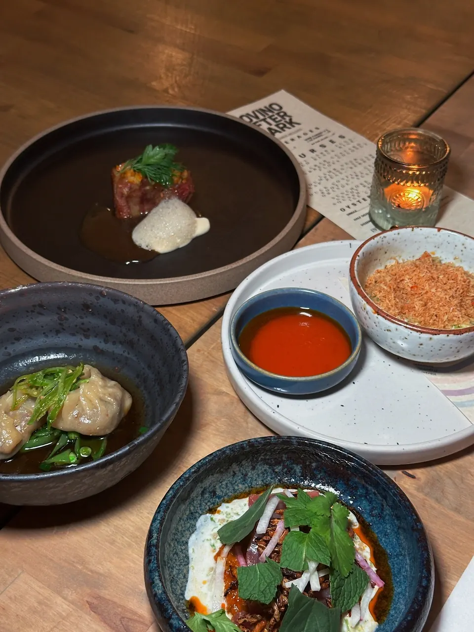 Tasting menu spread with tartare, dumplings, and crudo